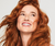 Redhaired girl smiling from the front